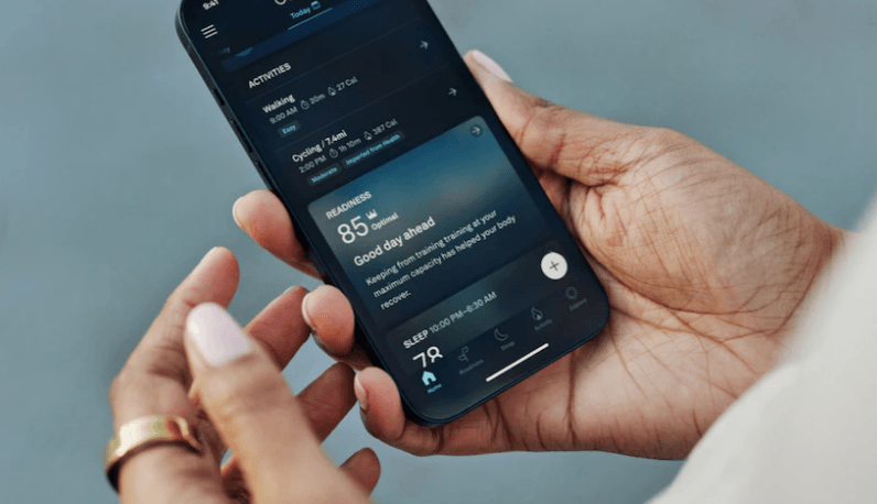 Person holding smartphone displaying a health and activity tracking app with readiness score.